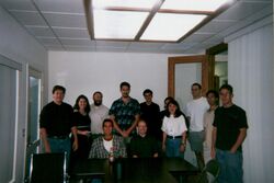 Ten people are standing in the rear while two people, Sanger among them to the viewer's right, are seated in the front.