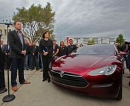 Musk converses with US Senator Dianne Feinstein beside a red Tesla